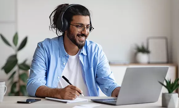 Student sitzt zuhause vor seinem Laptop und lernt