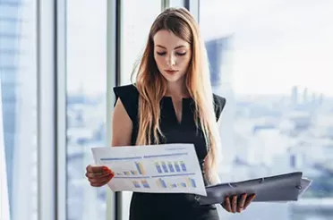 Business Frau schaut auf ein Dokument mit Zahlen